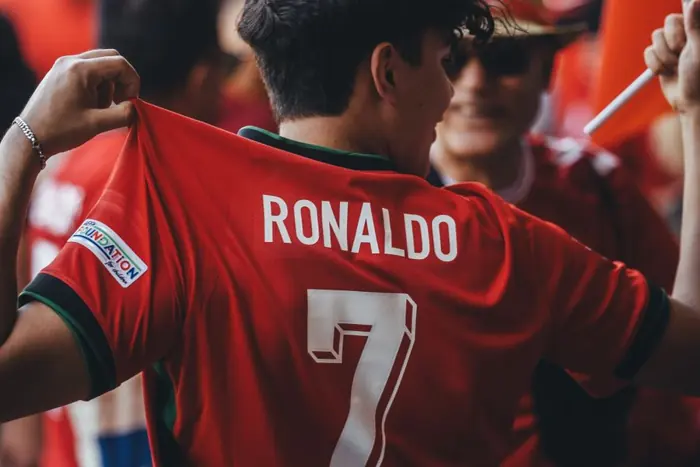 Aficionado mostrando el nombre y número en la espalda de su camiseta